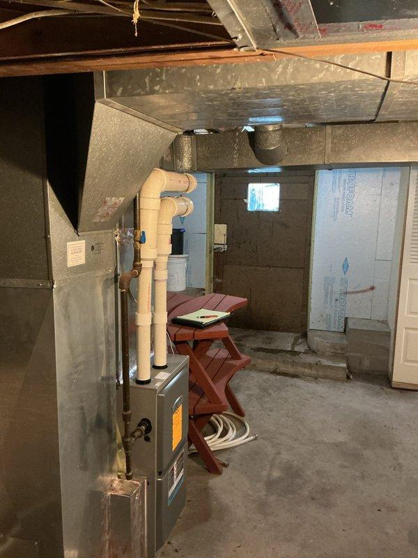 Provided estimate for water heater replacement with natural gas conversion and modification of HVAC supply registers in basement utility area. Assessed existing Rheem electric water heater and evaluated space requirements for new gas-fired unit, including necessary gas line installation, venting requirements, and code compliance considerations. Documented current HVAC system configuration with metal ductwork and beige PVC piping, and identified supply registers requiring replacement or modification to improve airflow distribution.