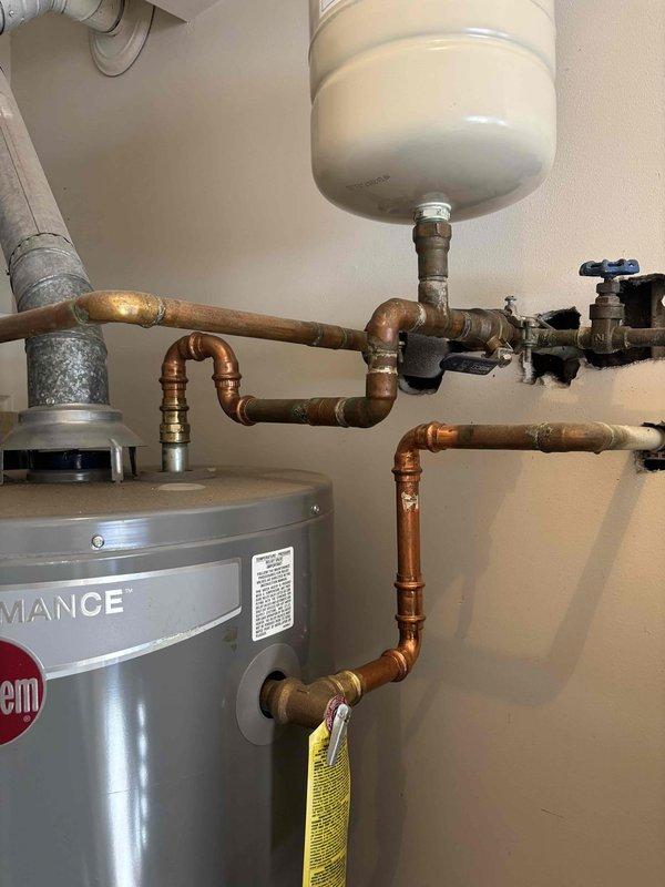 Responded to customer complaint of brown hot water from Rheem Performance standard water heater. Performed visual inspection of unit and plumbing system, noting copper pipes showing significant oxidation and sediment buildup. Flushed water heater tank to remove accumulated sediment causing discoloration, cleaned inlet screen, and verified proper operation of temperature/pressure relief valve. System now producing clear water with normal flow and temperature. Responded to customer complaint of brown hot water from Rheem Performance standard water heater. Performed visual inspection of unit and plumbing system, noting copper pipes showing significant oxidation and sediment buildup. Flushed water heater tank to remove accumulated sediment causing discoloration, cleaned inlet screen, and verified proper operation of temperature/pressure relief valve. System now producing clear water with normal flow and temperature.