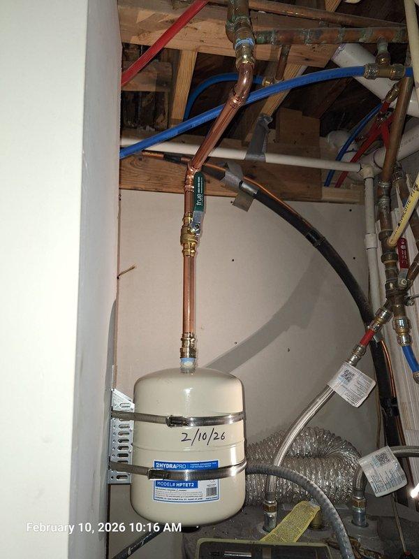 Identified water leak in laundry room ceiling originating from master bathroom above. Inspection revealed hydronic expansion tank with improper installation causing leak. Replaced expansion tank with new HYDRONIC model HFT, secured properly with metal straps, and verified all connections at copper pipe assembly and brass fittings. Tested system for proper operation and confirmed no further leakage. Identified water leak in laundry room ceiling originating from master bathroom above. Inspection revealed hydronic expansion tank with improper installation causing leak. Replaced expansion tank with new HYDRONIC model HFT, secured properly with metal straps, and verified all connections at copper pipe assembly and brass fittings. Tested system for proper operation and confirmed no further leakage.