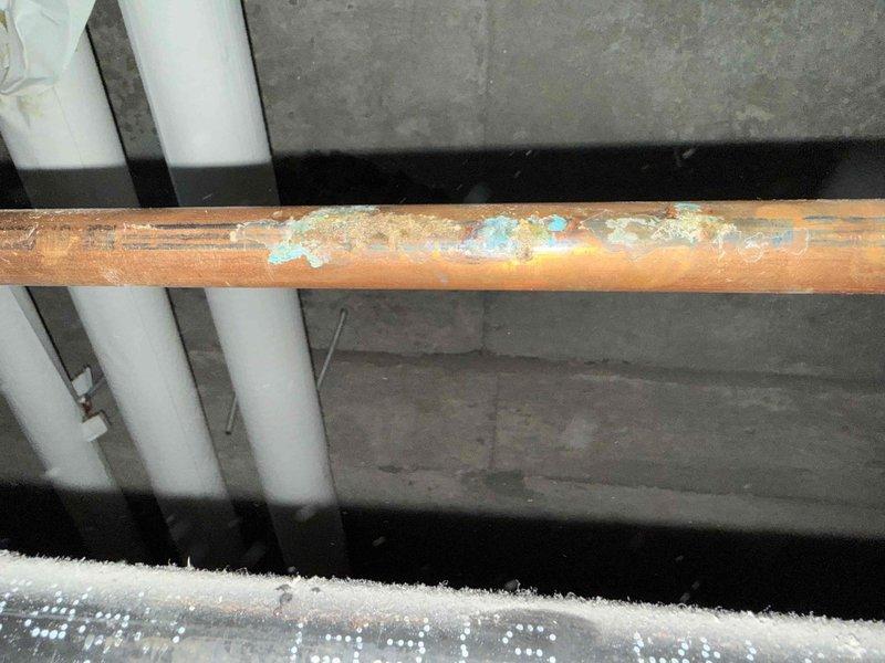 Inspected water heater system reporting leakage. Identified severely corroded copper supply line with visible blue-green oxidation and mineral deposits as source of leak. Found compromised pipe insulation with exposed fiberglass material in the mechanical space. Replacement of affected copper piping section recommended to prevent further water damage. Inspected water heater system reporting leakage. Identified severely corroded copper supply line with visible blue-green oxidation and mineral deposits as source of leak. Found compromised pipe insulation with exposed fiberglass material in the mechanical space. Replacement of affected copper piping section recommended to prevent further water damage.