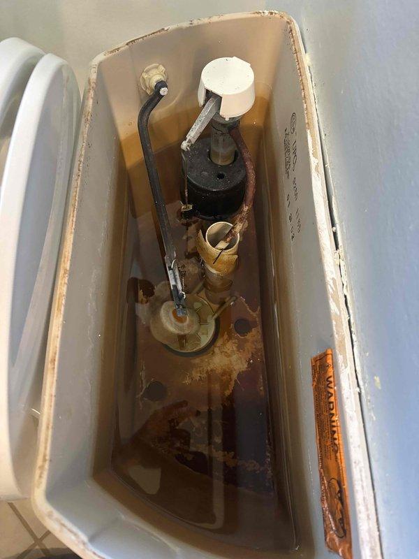 Responded to service call for clogged toilet. Upon inspection, found significant mineral buildup and corrosion in tank components with rusty water. Performed pressure test (reading approximately 100 psi) and cleared blockage. Recommended replacement of aging internal flush components to prevent future clogs. Responded to service call for clogged toilet. Upon inspection, found significant mineral buildup and corrosion in tank components with rusty water. Performed pressure test (reading approximately 100 psi) and cleared blockage. Recommended replacement of aging internal flush components to prevent future clogs.