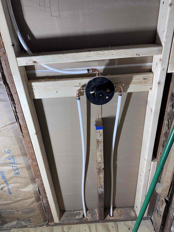 Completed follow-up inspection of plumbing installation project. Documented exposed wall section showing proper installation of black circular valve with copper and PVC connections. Additional documentation of underfloor/crawlspace area confirmed proper installation of drainage pipes, water supply lines, and HVAC ductwork running between floor joists. Completed follow-up inspection of plumbing installation project. Documented exposed wall section showing proper installation of black circular valve with copper and PVC connections. Additional documentation of underfloor/crawlspace area confirmed proper installation of drainage pipes, water supply lines, and HVAC ductwork running between floor joists.