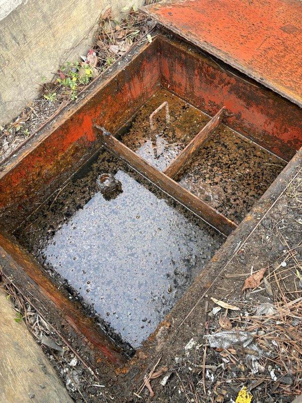 Performed approved jetting service on severely corroded metal catch basin system showing multiple compartments with standing water and sediment buildup. Cleared rectangular drain opening and surrounding concrete drainage area where water was pooling. Customer was provided with recommendation for permanent repair due to extensive rust damage and deterioration observed throughout the drainage structure. Performed approved jetting service on severely corroded metal catch basin system showing multiple compartments with standing water and sediment buildup. Cleared rectangular drain opening and surrounding concrete drainage area where water was pooling. Customer was provided with recommendation for permanent repair due to extensive rust damage and deterioration observed throughout the drainage structure.