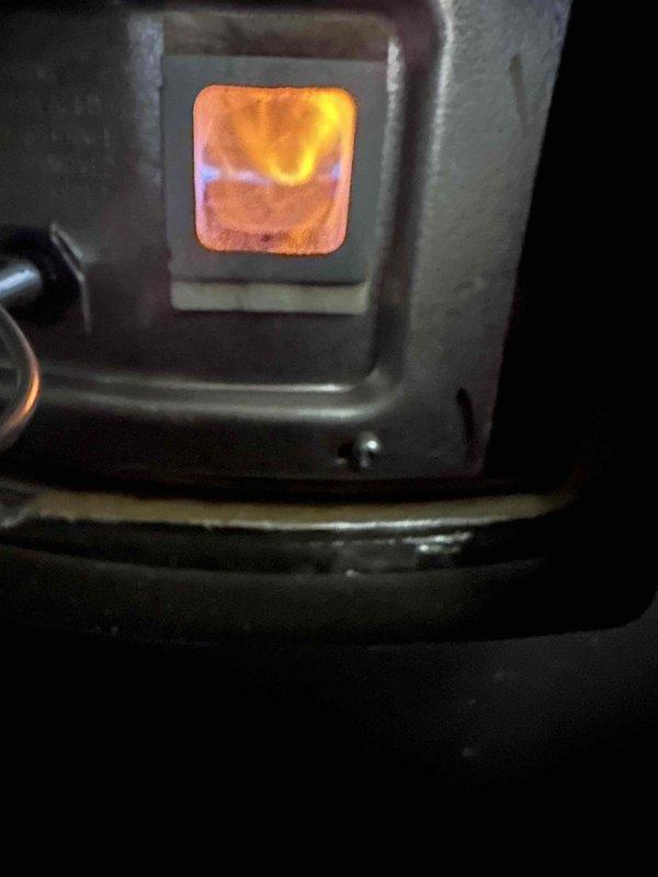 Inspected water heater installed approximately one year ago that had water accumulating in the drain pan. Verified proper burner operation through sight glass and examined installation area. Found no active leaks at water connections or TPR valve, suggesting condensation or previous minor leak that has since stopped. Inspected water heater installed approximately one year ago that had water accumulating in the drain pan. Verified proper burner operation through sight glass and examined installation area. Found no active leaks at water connections or TPR valve, suggesting condensation or previous minor leak that has since stopped.