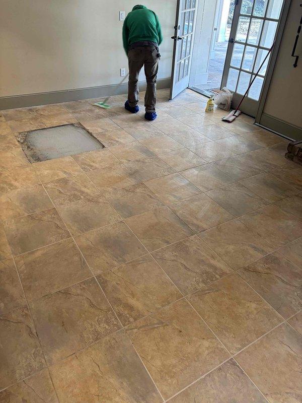 Performed site assessment for ceramic tile repair. Identified one missing floor tile in tan/beige tiled area near French doors. Documented existing flooring pattern and substrate condition for proper replacement material selection. Performed site assessment for ceramic tile repair. Identified one missing floor tile in tan/beige tiled area near French doors. Documented existing flooring pattern and substrate condition for proper replacement material selection.