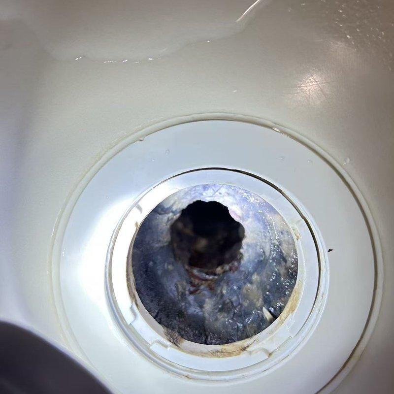 Responded to service call for a shower drain leak. Upon inspection, discovered deteriorated drain seal with significant corrosion and mineral buildup causing water to leak through to the basement. Observed water damage where the drain pipe penetrates the floor structure, with visible white mineral deposits tracking down the black PVC pipe below. Responded to service call for a shower drain leak. Upon inspection, discovered deteriorated drain seal with significant corrosion and mineral buildup causing water to leak through to the basement. Observed water damage where the drain pipe penetrates the floor structure, with visible white mineral deposits tracking down the black PVC pipe below.