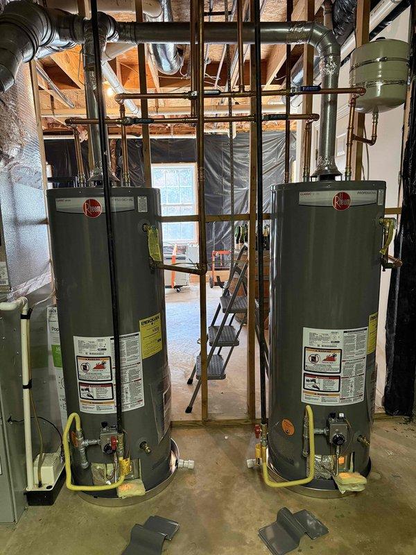 Completed installation of dual 50-gallon gas water heaters in basement utility area, including proper connection of copper pipes and yellow gas lines. Both Rheem units were secured side-by-side with appropriate venting and all required safety components installed according to specifications. Completed installation of dual 50-gallon gas water heaters in basement utility area, including proper connection of copper pipes and yellow gas lines. Both Rheem units were secured side-by-side with appropriate venting and all required safety components installed according to specifications.