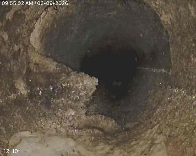 Conducted sewer scope inspection of main line, documenting conditions at approximately 12'10" depth. Observed significant rust and mineral buildup along the upper portions of the pipe with sediment accumulation along the bottom surface. Inspection revealed pipe narrowing with potential scaling issues, though flow appeared unobstructed at time of service. Conducted sewer scope inspection of main line, documenting conditions at approximately 12'10" depth. Observed significant rust and mineral buildup along the upper portions of the pipe with sediment accumulation along the bottom surface. Inspection revealed pipe narrowing with potential scaling issues, though flow appeared unobstructed at time of service.