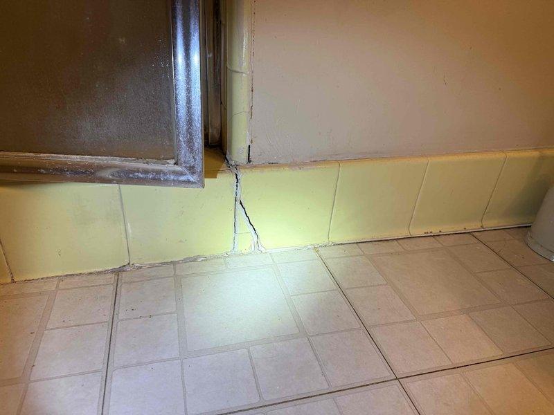 Conducted follow-up inspection of customer's property following restoration company's wall opening. Documented extensive water damage, including structural cracking in wainscoting, floor tile deterioration, and black mold growth at wall-floor junctions. Identified accessible leaking pipe through the opened wall section and assessed internal toilet components requiring replacement. Conducted follow-up inspection of customer's property following restoration company's wall opening. Documented extensive water damage, including structural cracking in wainscoting, floor tile deterioration, and black mold growth at wall-floor junctions. Identified accessible leaking pipe through the opened wall section and assessed internal toilet components requiring replacement.