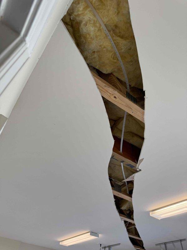 Rerouted hose spigot piping through existing wall structure, replacing damaged connections with new Hi-Flo fittings. Accessed ceiling joists to properly route supply line, ensuring proper insulation clearance around the new plumbing pathway.