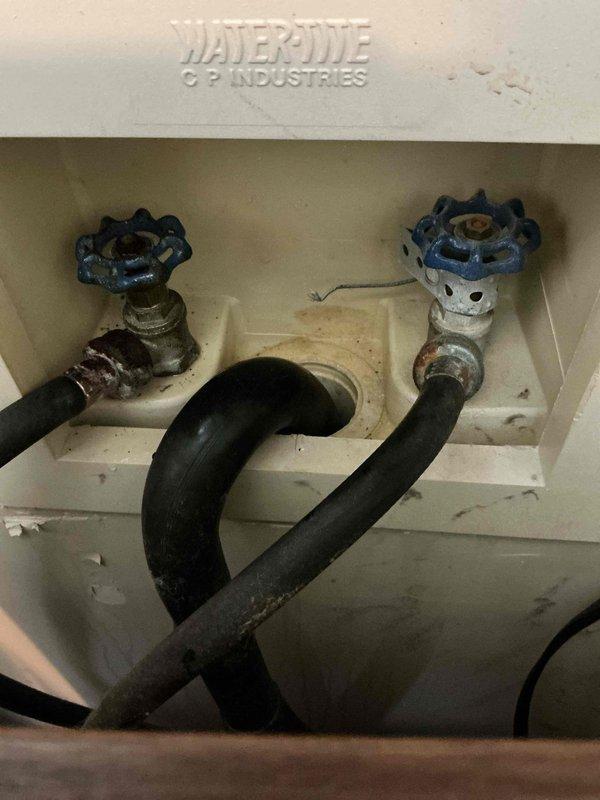 Responded to service call for leaky hot water spigot in WaterOne/WaterPure washing machine connection box. Inspected and replaced corroded hot water valve that was showing significant mineral buildup and staining in the housing. Customer also reported reduced hot water duration; recommended water heater flush service as preventative maintenance to address this separate issue.