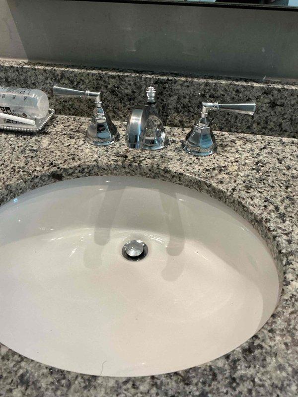 Responded to service call regarding reduced water flow from kitchen faucet. Upon inspection, discovered mineral buildup and oxidation on brass valve stems causing restriction in water flow. Cleaned valve components, removing accumulated mineral deposits and corrosion from the three-piece chrome faucet assembly mounted on granite countertop, successfully restoring proper water flow and functionality. Responded to service call regarding reduced water flow from kitchen faucet. Upon inspection, discovered mineral buildup and oxidation on brass valve stems causing restriction in water flow. Cleaned valve components, removing accumulated mineral deposits and corrosion from the three-piece chrome faucet assembly mounted on granite countertop, successfully restoring proper water flow and functionality.