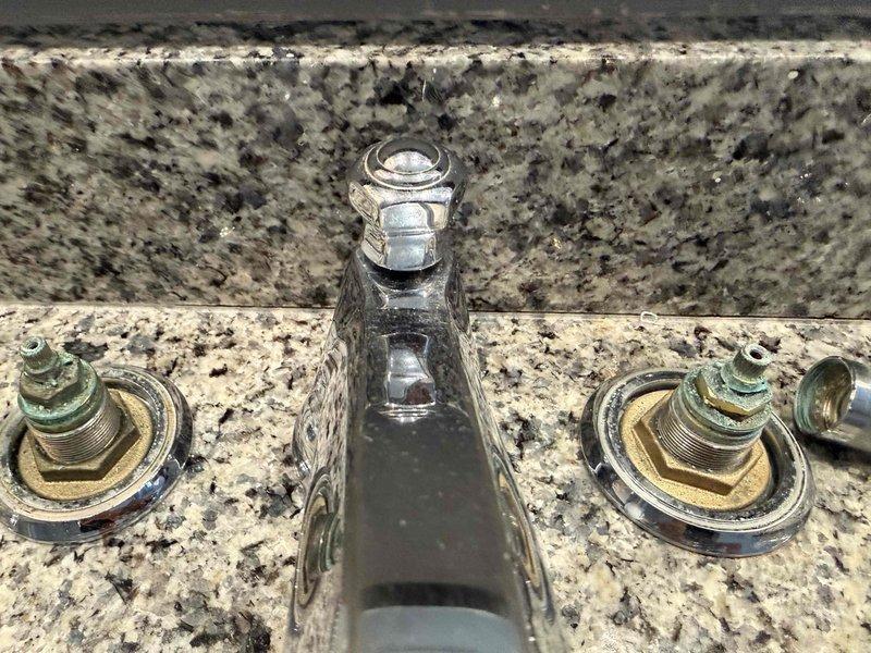 Responded to service call regarding reduced water flow from kitchen faucet. Upon inspection, discovered mineral buildup and oxidation on brass valve stems causing restriction in water flow. Cleaned valve components, removing accumulated mineral deposits and corrosion from the three-piece chrome faucet assembly mounted on granite countertop, successfully restoring proper water flow and functionality. Responded to service call regarding reduced water flow from kitchen faucet. Upon inspection, discovered mineral buildup and oxidation on brass valve stems causing restriction in water flow. Cleaned valve components, removing accumulated mineral deposits and corrosion from the three-piece chrome faucet assembly mounted on granite countertop, successfully restoring proper water flow and functionality.