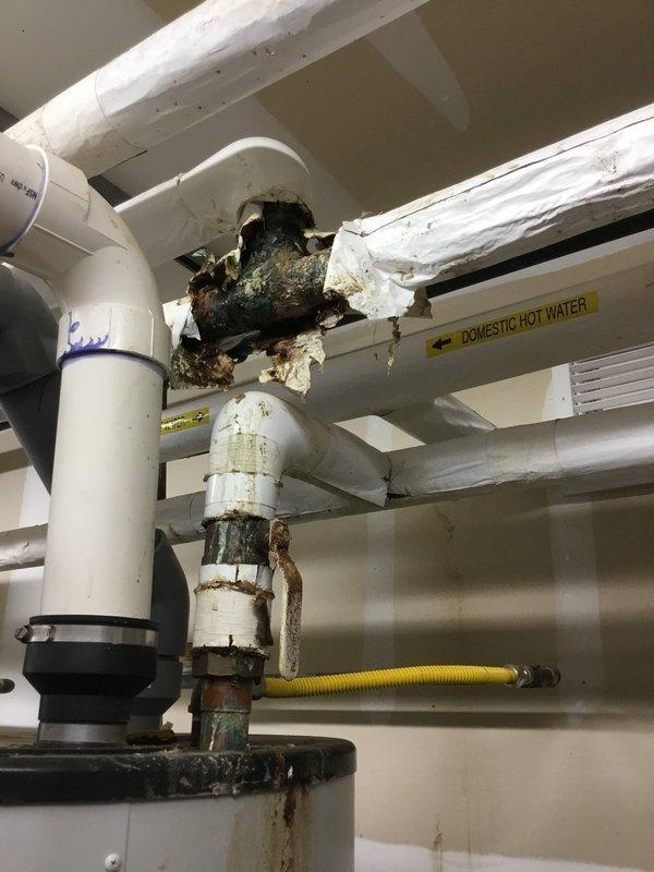 Performed inspection of domestic hot water system with significant corrosion and pipe failure at connection point between PVC and metal piping. Documented severe deterioration, visible hole in insulated section, and evidence of active leaking with rust and mineral deposits. Recommend immediate replacement of damaged section to prevent further water damage and potential system failure. Performed inspection of domestic hot water system with significant corrosion and pipe failure at connection point between PVC and metal piping. Documented severe deterioration, visible hole in insulated section, and evidence of active leaking with rust and mineral deposits. Recommend immediate replacement of damaged section to prevent further water damage and potential system failure.