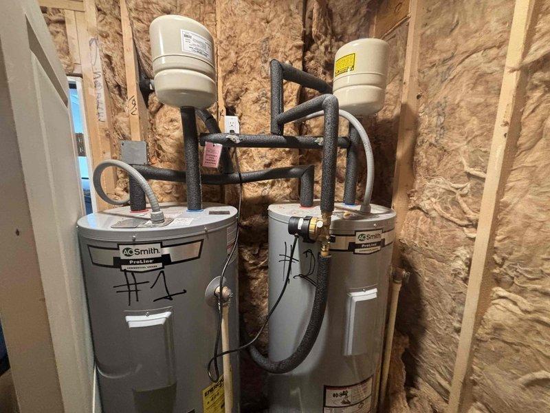 Diagnosed parallel electric water heater system experiencing lukewarm water output and occasional breaker trips on one unit. Inspected A.O. Smith dual tank installation with expansion tanks and observed possible cross-connection issue between units. Documented system configuration with photographs for further evaluation by management regarding appropriate resolution options. Diagnosed parallel electric water heater system experiencing lukewarm water output and occasional breaker trips on one unit. Inspected A.O. Smith dual tank installation with expansion tanks and observed possible cross-connection issue between units. Documented system configuration with photographs for further evaluation by management regarding appropriate resolution options.