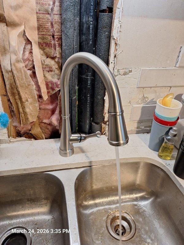 Responded to kitchen sink leak reported beneath the basin. Upon inspection, discovered water infiltration had caused significant deterioration to the wall cavity behind the sink, with extensive moisture damage to drywall and visible staining on interior framing. Assessed the complete under-sink plumbing assembly, including double-basin configuration with garbage disposal unit, PVC drain lines, P-traps, and dishwasher connection. Tightened loose faucet mounting hardware and supply line connections that were causing the drip beneath the sink. Verified proper sealing of all drain connections and inspected hose clamps on flexible lines for secure attachment. Tested faucet operation and checked all plumbing connections for leaks after repairs were completed. Responded to kitchen sink leak reported beneath the basin. Upon inspection, discovered water infiltration had caused significant deterioration to the wall cavity behind the sink, with extensive moisture damage to drywall and visible staining on interior framing. Assessed the complete under-sink plumbing assembly, including double-basin configuration with garbage disposal unit, PVC drain lines, P-traps, and dishwasher connection. Tightened loose faucet mounting hardware and supply line connections that were causing the drip beneath the sink. Verified proper sealing of all drain connections and inspected hose clamps on flexible lines for secure attachment. Tested faucet operation and checked all plumbing connections for leaks after repairs were completed.