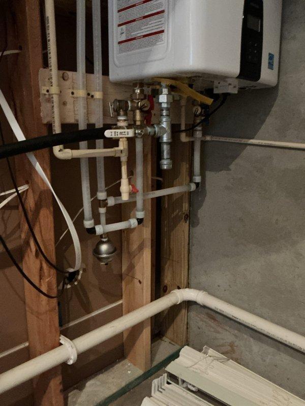 Completed tankless water heater upgrade installation, replacing existing conventional water heating system. Installed new wall-mounted tankless unit with proper venting, gas connections, and integrated plumbing network including PEX supply lines, copper piping, shut-off valves with isolation capability, and pressure relief components. All connections secured to structural framing per code requirements, system tested and verified operational. Completed tankless water heater upgrade installation, replacing existing conventional water heating system. Installed new wall-mounted tankless unit with proper venting, gas connections, and integrated plumbing network including PEX supply lines, copper piping, shut-off valves with isolation capability, and pressure relief components. All connections secured to structural framing per code requirements, system tested and verified operational.