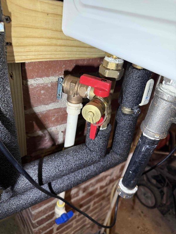 Responded to service call for tankless water heater continuously discharging water following recent renovations. Upon inspection, identified improperly installed or malfunctioning temperature and pressure relief (TPR) valve assembly causing excessive water discharge. Examined plumbing connections beneath unit including brass fittings, ball valves, and PVC discharge piping. Verified proper installation of TPR valve with appropriate discharge piping routing. Inspected overhead plumbing infrastructure in attic space, including PEX supply lines and associated connections to ensure no cross-connection issues or pressure irregularities contributing to the problem. Corrected installation deficiencies and verified system operation with no further discharge occurring. Responded to service call for tankless water heater continuously discharging water following recent renovations. Upon inspection, identified improperly installed or malfunctioning temperature and pressure relief (TPR) valve assembly causing excessive water discharge. Examined plumbing connections beneath unit including brass fittings, ball valves, and PVC discharge piping. Verified proper installation of TPR valve with appropriate discharge piping routing. Inspected overhead plumbing infrastructure in attic space, including PEX supply lines and associated connections to ensure no cross-connection issues or pressure irregularities contributing to the problem. Corrected installation deficiencies and verified system operation with no further discharge occurring.