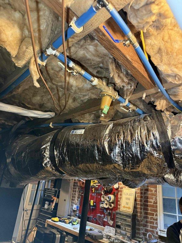 Responded to service call for tankless water heater continuously discharging water following recent renovations. Upon inspection, identified improperly installed or malfunctioning temperature and pressure relief (TPR) valve assembly causing excessive water discharge. Examined plumbing connections beneath unit including brass fittings, ball valves, and PVC discharge piping. Verified proper installation of TPR valve with appropriate discharge piping routing. Inspected overhead plumbing infrastructure in attic space, including PEX supply lines and associated connections to ensure no cross-connection issues or pressure irregularities contributing to the problem. Corrected installation deficiencies and verified system operation with no further discharge occurring. Responded to service call for tankless water heater continuously discharging water following recent renovations. Upon inspection, identified improperly installed or malfunctioning temperature and pressure relief (TPR) valve assembly causing excessive water discharge. Examined plumbing connections beneath unit including brass fittings, ball valves, and PVC discharge piping. Verified proper installation of TPR valve with appropriate discharge piping routing. Inspected overhead plumbing infrastructure in attic space, including PEX supply lines and associated connections to ensure no cross-connection issues or pressure irregularities contributing to the problem. Corrected installation deficiencies and verified system operation with no further discharge occurring.