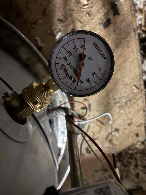 Responded to report of leak in ceiling. Upon inspection, located source in attic space where plumbing system components were installed. Examined water expansion tank mounted between wooden joists and associated piping connections. Identified leak originating from valve assembly and pipe fittings below expansion tank. Inspected pressure gauge on system which indicated proper pressure readings near zero. Checked all threaded brass connections and mounting points for signs of water intrusion. Tightened loose fittings and verified all connections were secure. Monitored system for additional leaks and confirmed repair was successful with no further water discharge detected. Responded to report of leak in ceiling. Upon inspection, located source in attic space where plumbing system components were installed. Examined water expansion tank mounted between wooden joists and associated piping connections. Identified leak originating from valve assembly and pipe fittings below expansion tank. Inspected pressure gauge on system which indicated proper pressure readings near zero. Checked all threaded brass connections and mounting points for signs of water intrusion. Tightened loose fittings and verified all connections were secure. Monitored system for additional leaks and confirmed repair was successful with no further water discharge detected.