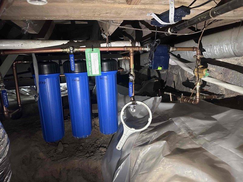 # Pressure Issue Resolution
Responded to low water pressure complaint affecting entire property. Upon inspection, located three-stage water filtration system in crawl space with clogged filter cartridges restricting flow. Replaced all filter elements in blue housing canisters, inspected copper piping and brass fittings for obstructions, and verified proper operation of associated pump unit. Tested water pressure at multiple fixtures throughout property and confirmed restoration to normal operating levels. # Pressure Issue Resolution
Responded to low water pressure complaint affecting entire property. Upon inspection, located three-stage water filtration system in crawl space with clogged filter cartridges restricting flow. Replaced all filter elements in blue housing canisters, inspected copper piping and brass fittings for obstructions, and verified proper operation of associated pump unit. Tested water pressure at multiple fixtures throughout property and confirmed restoration to normal operating levels.