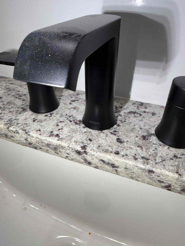 Completed installation and certification of compliance for two Moen faucet fixtures in a residential property. Installed a three-piece widespread bathroom faucet in matte black finish on granite countertop with porcelain sink basin, and a commercial-style pull-down kitchen faucet with coiled spring spout on granite countertop with stainless steel double-bowl sink. Both installations were photographed and documented to verify proper mounting, functionality, and compliance with manufacturer specifications and applicable plumbing codes. Completed installation and certification of compliance for two Moen faucet fixtures in a residential property. Installed a three-piece widespread bathroom faucet in matte black finish on granite countertop with porcelain sink basin, and a commercial-style pull-down kitchen faucet with coiled spring spout on granite countertop with stainless steel double-bowl sink. Both installations were photographed and documented to verify proper mounting, functionality, and compliance with manufacturer specifications and applicable plumbing codes.