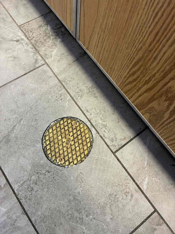 Replaced existing sewer cleanout lid with new brass-finished drain cover, securing it properly with mounting screws. The installation was completed on the tiled floor area, ensuring proper fit and functionality of the drainage system. Replaced existing sewer cleanout lid with new brass-finished drain cover, securing it properly with mounting screws. The installation was completed on the tiled floor area, ensuring proper fit and functionality of the drainage system.
