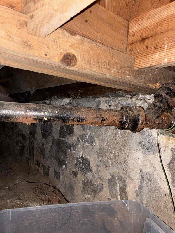Responded to service call for leaking cast iron drain pipe in crawlspace beneath kitchen. Upon inspection, discovered severely corroded cast iron piping with active deterioration and rust throughout the system, along with moisture damage to surrounding block wall surfaces indicating long-term water infiltration. Documented existing conditions including outdated S-trap configuration under kitchen sink, aging copper supply lines with tarnished connections, and deteriorated water filtration system. Provided comprehensive estimate for replacing corroded cast iron drain line, converting non-compliant S-trap to code-approved P-trap assembly, and installing new water heater to address customer's requested scope of work. Responded to service call for leaking cast iron drain pipe in crawlspace beneath kitchen. Upon inspection, discovered severely corroded cast iron piping with active deterioration and rust throughout the system, along with moisture damage to surrounding block wall surfaces indicating long-term water infiltration. Documented existing conditions including outdated S-trap configuration under kitchen sink, aging copper supply lines with tarnished connections, and deteriorated water filtration system. Provided comprehensive estimate for replacing corroded cast iron drain line, converting non-compliant S-trap to code-approved P-trap assembly, and installing new water heater to address customer's requested scope of work.