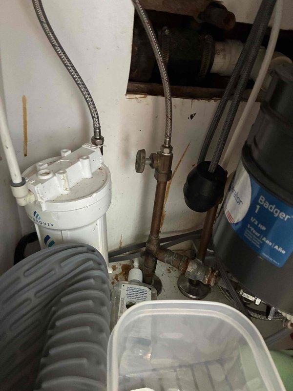 Responded to service call for leaking cast iron drain pipe in crawlspace beneath kitchen. Upon inspection, discovered severely corroded cast iron piping with active deterioration and rust throughout the system, along with moisture damage to surrounding block wall surfaces indicating long-term water infiltration. Documented existing conditions including outdated S-trap configuration under kitchen sink, aging copper supply lines with tarnished connections, and deteriorated water filtration system. Provided comprehensive estimate for replacing corroded cast iron drain line, converting non-compliant S-trap to code-approved P-trap assembly, and installing new water heater to address customer's requested scope of work. Responded to service call for leaking cast iron drain pipe in crawlspace beneath kitchen. Upon inspection, discovered severely corroded cast iron piping with active deterioration and rust throughout the system, along with moisture damage to surrounding block wall surfaces indicating long-term water infiltration. Documented existing conditions including outdated S-trap configuration under kitchen sink, aging copper supply lines with tarnished connections, and deteriorated water filtration system. Provided comprehensive estimate for replacing corroded cast iron drain line, converting non-compliant S-trap to code-approved P-trap assembly, and installing new water heater to address customer's requested scope of work.