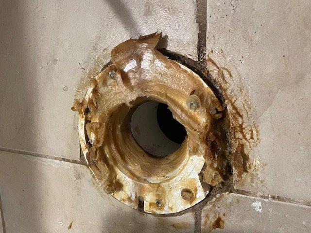 Responded to repair call for unstable toilet resulting from previous improper installation. Upon inspection, found severely cracked toilet flange with extensive water damage and corrosion around the mounting area. The toilet was rocking due to improper leveling and failed plastic mounting bolts from a substandard repair completed three months prior.
Removed the toilet and existing damaged flange assembly. Assessed the condition of the waste pipe and subfloor, noting significant deterioration around the flange area with mineral deposits and moisture damage to surrounding tiles and grout. The PVC drain pipe remained structurally sound beneath the failed flange connection.
Installed new code-compliant toilet flange with proper mechanical fasteners to ensure secure mounting to the subfloor. Cleaned and prepared the mounting surface, removing all deteriorated material and buildup from the previous installation. Set the toilet with new wax ring seal, ensuring proper alignment and level in Responded to repair call for unstable toilet resulting from previous improper installation. Upon inspection, found severely cracked toilet flange with extensive water damage and corrosion around the mounting area. The toilet was rocking due to improper leveling and failed plastic mounting bolts from a substandard repair completed three months prior.
Removed the toilet and existing damaged flange assembly. Assessed the condition of the waste pipe and subfloor, noting significant deterioration around the flange area with mineral deposits and moisture damage to surrounding tiles and grout. The PVC drain pipe remained structurally sound beneath the failed flange connection.
Installed new code-compliant toilet flange with proper mechanical fasteners to ensure secure mounting to the subfloor. Cleaned and prepared the mounting surface, removing all deteriorated material and buildup from the previous installation. Set the toilet with new wax ring seal, ensuring proper alignment and level in
