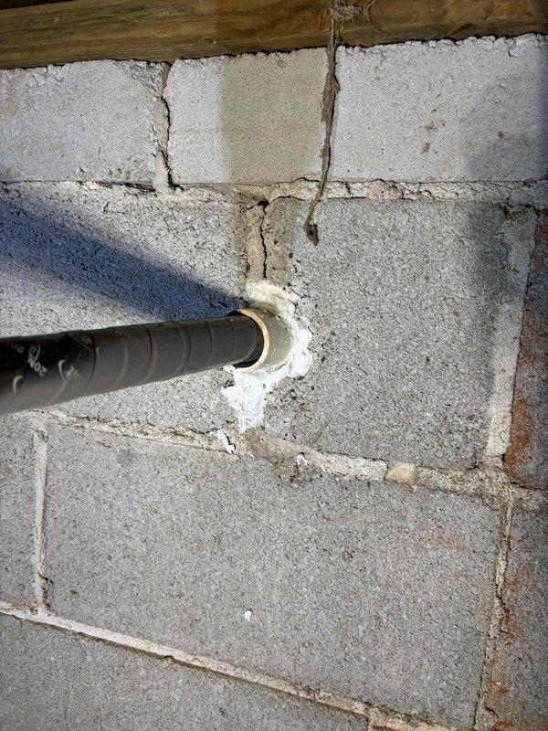 Completed gas line repair involving excavation and access to underground piping system. Repaired compromised gas line connection at elbow joint located beneath grade level in clay soil conditions. Sealed pipe penetration through concrete block foundation wall using expanding foam to ensure proper weatherproofing and prevent air infiltration. Documented existing conditions showing PVC conduit installation and underground junction point with standing water present at base of excavation. Completed gas line repair involving excavation and access to underground piping system. Repaired compromised gas line connection at elbow joint located beneath grade level in clay soil conditions. Sealed pipe penetration through concrete block foundation wall using expanding foam to ensure proper weatherproofing and prevent air infiltration. Documented existing conditions showing PVC conduit installation and underground junction point with standing water present at base of excavation.