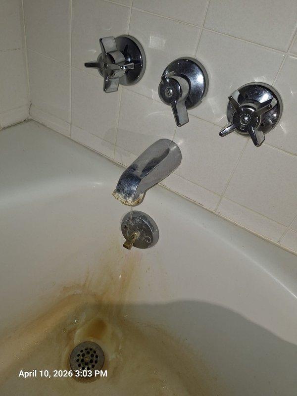 Responded to water department notice regarding continuous water flow at property. Upon inspection, identified leaking bathtub faucet assembly with three-valve cross-handle configuration as source of constant water flow. Tub showed significant rust-colored staining and mineral deposit buildup around drain area, indicating prolonged water seepage. Repaired faulty valve stem washers and seats on the affected fixture, restoring proper shutoff function and eliminating continuous water flow condition. Responded to water department notice regarding continuous water flow at property. Upon inspection, identified leaking bathtub faucet assembly with three-valve cross-handle configuration as source of constant water flow. Tub showed significant rust-colored staining and mineral deposit buildup around drain area, indicating prolonged water seepage. Repaired faulty valve stem washers and seats on the affected fixture, restoring proper shutoff function and eliminating continuous water flow condition.