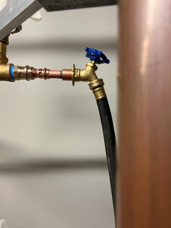Completed installation of water heater isolation valve with blue handle on main supply line. Valve installed on copper piping to provide shut-off capability for the Rheem water heater system. All connections properly secured with brass fittings, and flexible connector attached to valve outlet. System tested for leaks and proper operation confirmed. Completed installation of water heater isolation valve with blue handle on main supply line. Valve installed on copper piping to provide shut-off capability for the Rheem water heater system. All connections properly secured with brass fittings, and flexible connector attached to valve outlet. System tested for leaks and proper operation confirmed.