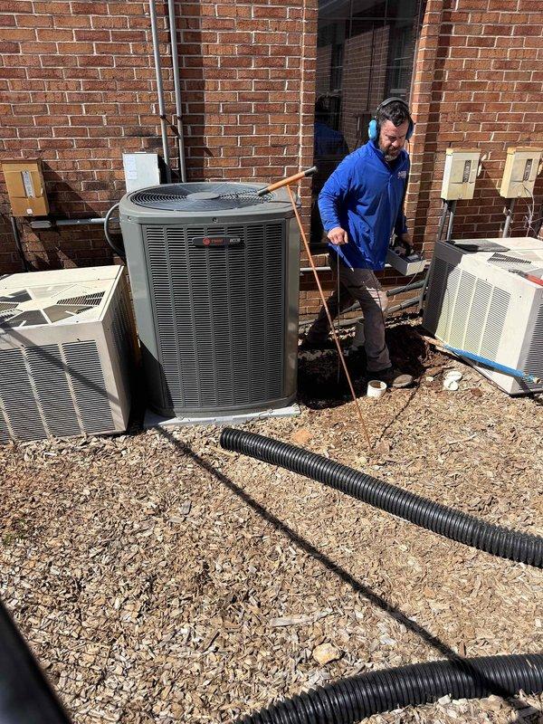 Responded to water service leak call with arrival on site at 9am for leak detection. Upon inspection, identified compromised ground-level area beneath HVAC unit with visible moisture saturation in soil and mulch. Investigated circular access opening approximately 6-8 inches in diameter showing signs of water intrusion. Assessed corroded condensate drip pan beneath air conditioning unit displaying significant rust deterioration, indicating prolonged exposure to moisture. Documented conditions with photographic evidence of affected areas including deteriorated metal components and saturated ground conditions. Proceeded to rooftop to inspect additional HVAC equipment and trace potential water service connections. Examined multiple Trane AC units and associated plumbing infrastructure including PVC piping and drainage systems. Coordinated with team via phone communication while conducting thorough assessment of rooftop installations and utility connections. Completed comprehensive leak det Responded to water service leak call with arrival on site at 9am for leak detection. Upon inspection, identified compromised ground-level area beneath HVAC unit with visible moisture saturation in soil and mulch. Investigated circular access opening approximately 6-8 inches in diameter showing signs of water intrusion. Assessed corroded condensate drip pan beneath air conditioning unit displaying significant rust deterioration, indicating prolonged exposure to moisture. Documented conditions with photographic evidence of affected areas including deteriorated metal components and saturated ground conditions. Proceeded to rooftop to inspect additional HVAC equipment and trace potential water service connections. Examined multiple Trane AC units and associated plumbing infrastructure including PVC piping and drainage systems. Coordinated with team via phone communication while conducting thorough assessment of rooftop installations and utility connections. Completed comprehensive leak det