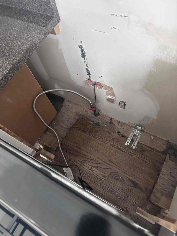 Relocated gas supply line to accommodate appliance repositioning. Installed new flexible gas connector with shutoff valve and floor-mounted brass fitting secured to concrete base. Routed metallic conduit from floor connection point to appliance inlet, ensuring proper clearances and code-compliant installation. Completed work in area with existing flooring damage and wall modifications from previous renovations. Relocated gas supply line to accommodate appliance repositioning. Installed new flexible gas connector with shutoff valve and floor-mounted brass fitting secured to concrete base. Routed metallic conduit from floor connection point to appliance inlet, ensuring proper clearances and code-compliant installation. Completed work in area with existing flooring damage and wall modifications from previous renovations.