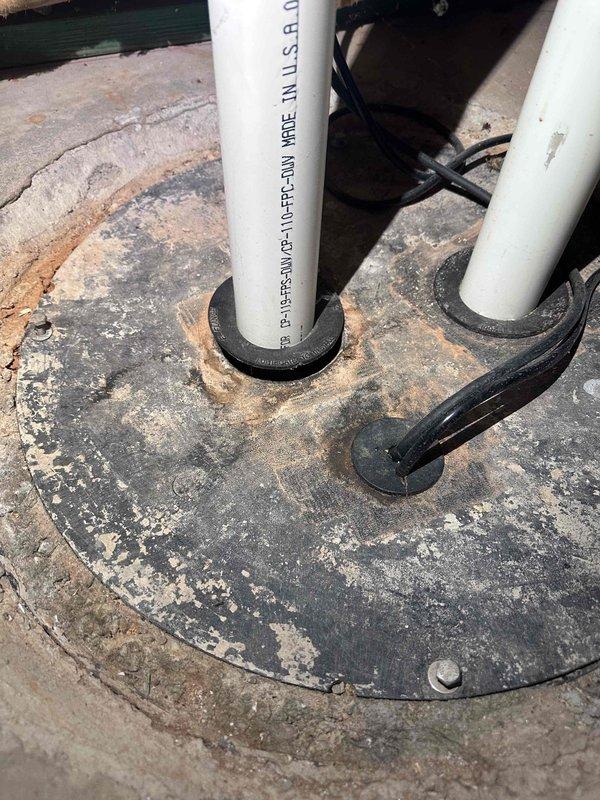 Responded to customer complaint of sewer odor in basement. Conducted thorough inspection of plumbing system and ventilation components. Investigation traced odor source to rooftop plumbing vents. Documented two separate vent pipe penetrations through roof surface, including weathered PVC Schedule 40 DWV piping passing through metal access cover and roof flashing assembly. Observed significant deterioration of roof membrane and sealing components around vent penetrations, indicating potential pathways for sewer gas infiltration back into building envelope. Photographed conditions showing compromised rubber grommets and deteriorated flashing boots that could allow gas bypass. Recommended resealing vent penetrations and evaluating vent stack termination heights to ensure proper atmospheric venting and prevent negative pressure conditions that draw sewer gases into occupied spaces. Responded to customer complaint of sewer odor in basement. Conducted thorough inspection of plumbing system and ventilation components. Investigation traced odor source to rooftop plumbing vents. Documented two separate vent pipe penetrations through roof surface, including weathered PVC Schedule 40 DWV piping passing through metal access cover and roof flashing assembly. Observed significant deterioration of roof membrane and sealing components around vent penetrations, indicating potential pathways for sewer gas infiltration back into building envelope. Photographed conditions showing compromised rubber grommets and deteriorated flashing boots that could allow gas bypass. Recommended resealing vent penetrations and evaluating vent stack termination heights to ensure proper atmospheric venting and prevent negative pressure conditions that draw sewer gases into occupied spaces.