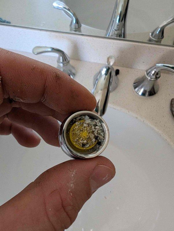 Responded to complaint of sewer odor in bathroom. Upon inspection, identified severe mineral buildup and debris in faucet aerator, which was removed and documented. Also discovered significant rust corrosion and deterioration on toilet tank-to-bowl mounting hardware with visible water staining, indicating a potential source of sewer gas infiltration through compromised seal integrity. Responded to complaint of sewer odor in bathroom. Upon inspection, identified severe mineral buildup and debris in faucet aerator, which was removed and documented. Also discovered significant rust corrosion and deterioration on toilet tank-to-bowl mounting hardware with visible water staining, indicating a potential source of sewer gas infiltration through compromised seal integrity.