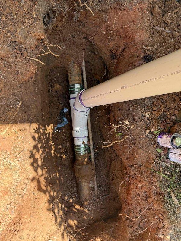 Excavated trench and installed new PVC cleanout access point with proper fittings and capped termination. Completed installation in landscaped area adjacent to building foundation, ensuring proper depth and accessibility while working around existing decorative rock borders and vegetation. Excavated trench and installed new PVC cleanout access point with proper fittings and capped termination. Completed installation in landscaped area adjacent to building foundation, ensuring proper depth and accessibility while working around existing decorative rock borders and vegetation.