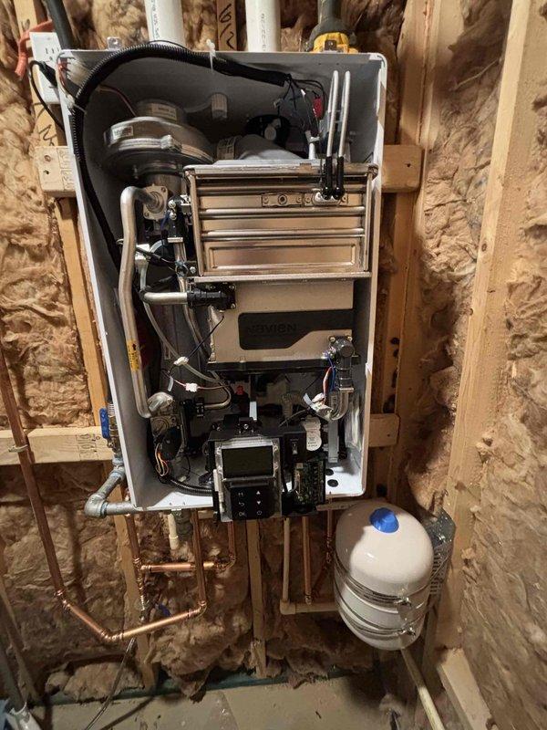 Completed installation of tankless water heating system in residential utility space. Removed existing tank-style water heaters and installed new wall-mounted tankless unit with integrated expansion tank, copper supply lines, and proper venting. Configured plumbing connections, mounted unit to structural framing with appropriate backing, and verified all gas lines, water connections, and electrical components were properly installed and functioning to manufacturer specifications. Completed installation of tankless water heating system in residential utility space. Removed existing tank-style water heaters and installed new wall-mounted tankless unit with integrated expansion tank, copper supply lines, and proper venting. Configured plumbing connections, mounted unit to structural framing with appropriate backing, and verified all gas lines, water connections, and electrical components were properly installed and functioning to manufacturer specifications.