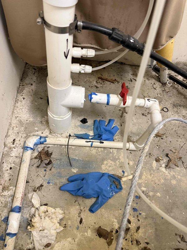 Responded to customer concern regarding potential leak and winterization quality at pool house. Upon inspection, documented existing plumbing configuration including white PVC piping system with vertical and horizontal runs, drainage components, and associated valves. Photographed current installation showing pipe arrangements, mounting brackets, and overall system layout to verify winterization procedures were completed per standard protocol. All pipes, fittings, and connections examined for proper installation and leak points. Work area conditions documented for service records.