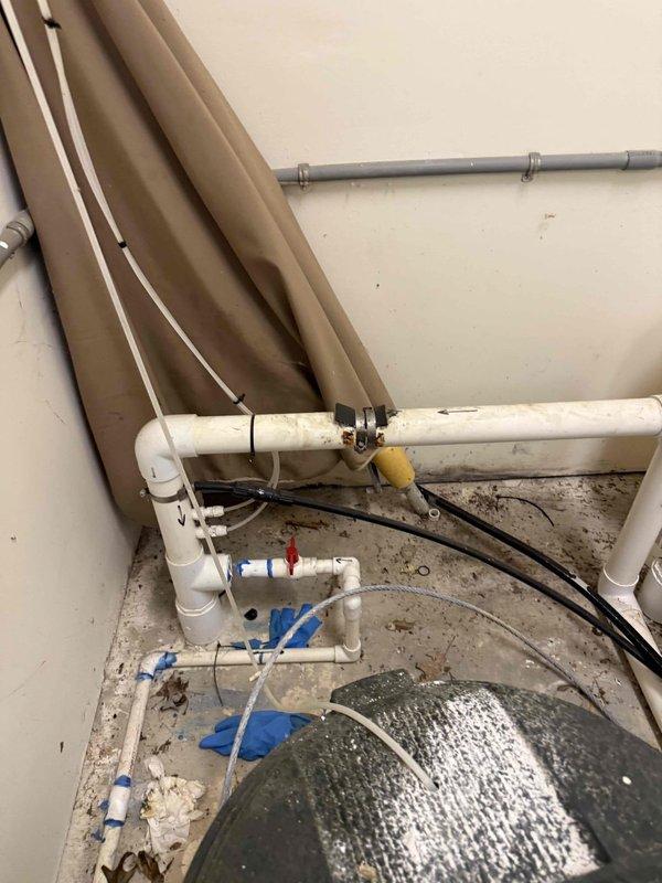 Responded to customer concern regarding potential leak and winterization quality at pool house. Upon inspection, documented existing plumbing configuration including white PVC piping system with vertical and horizontal runs, drainage components, and associated valves. Photographed current installation showing pipe arrangements, mounting brackets, and overall system layout to verify winterization procedures were completed per standard protocol. All pipes, fittings, and connections examined for proper installation and leak points. Work area conditions documented for service records.