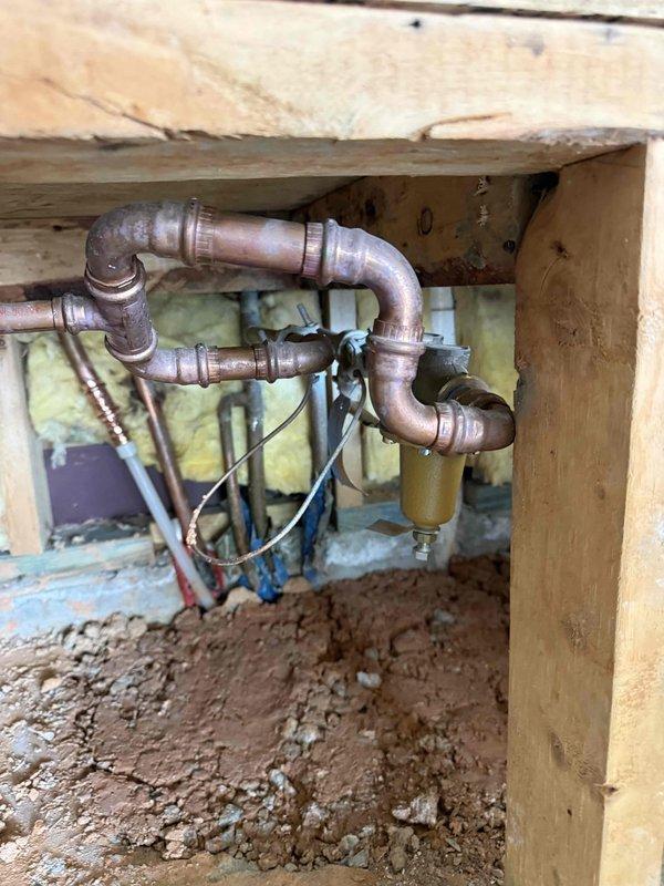 # Pressure Issue Resolution
Responded to customer complaint of squealing noise occurring in bathroom during water usage. Accessed crawlspace beneath bathroom to inspect plumbing system. Located source of noise at main water supply valve assembly where multiple copper and galvanized supply lines converge. Identified water hammer and pipe vibration caused by worn valve components and inadequate pipe support. Inspected brass valve assembly, copper piping connections, and associated fittings for signs of deterioration and improper installation. Found oxidized copper pipes with loose mounting allowing movement during water flow changes, creating the reported squealing sound. Documented existing conditions of aged plumbing system including weathered valve assembly, tarnished copper piping with patina buildup, and inadequate pipe securing to floor joists. Photographed valve junction point and horizontal copper pipe runs for service records. Recommended installation of water hammer arrestors, # Pressure Issue Resolution
Responded to customer complaint of squealing noise occurring in bathroom during water usage. Accessed crawlspace beneath bathroom to inspect plumbing system. Located source of noise at main water supply valve assembly where multiple copper and galvanized supply lines converge. Identified water hammer and pipe vibration caused by worn valve components and inadequate pipe support. Inspected brass valve assembly, copper piping connections, and associated fittings for signs of deterioration and improper installation. Found oxidized copper pipes with loose mounting allowing movement during water flow changes, creating the reported squealing sound. Documented existing conditions of aged plumbing system including weathered valve assembly, tarnished copper piping with patina buildup, and inadequate pipe securing to floor joists. Photographed valve junction point and horizontal copper pipe runs for service records. Recommended installation of water hammer arrestors,