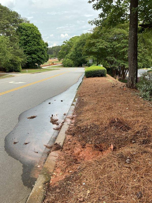Responded to water leak investigation at residential property where water pooling was observed approximately one foot from street curb. County utilities confirmed leak was located on customer's private side of service line. Upon arrival, documented extensive water damage with muddy runoff flowing from landscaped area across concrete curb onto asphalt roadway, creating brown sediment trails and standing water. Visual inspection revealed active water intrusion causing soil erosion in mulched landscape bed adjacent to sidewalk, with reddish-brown clay-rich sediment dispersing across hardscaped surfaces and into street. Photographed conditions showing water migration pattern from property landscape through curb area. No further action taken at this time pending customer decision on repair options for private-side water line leak. Responded to water leak investigation at residential property where water pooling was observed approximately one foot from street curb. County utilities confirmed leak was located on customer's private side of service line. Upon arrival, documented extensive water damage with muddy runoff flowing from landscaped area across concrete curb onto asphalt roadway, creating brown sediment trails and standing water. Visual inspection revealed active water intrusion causing soil erosion in mulched landscape bed adjacent to sidewalk, with reddish-brown clay-rich sediment dispersing across hardscaped surfaces and into street. Photographed conditions showing water migration pattern from property landscape through curb area. No further action taken at this time pending customer decision on repair options for private-side water line leak.