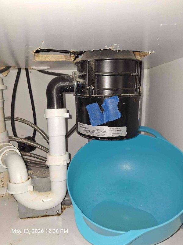 Installed new black garbage disposal unit under kitchen sink to replace customer's existing unit. Connected disposal to existing PVC drain line system and secured all plumbing connections. Wired electrical connections and tested unit for proper operation and drainage flow.