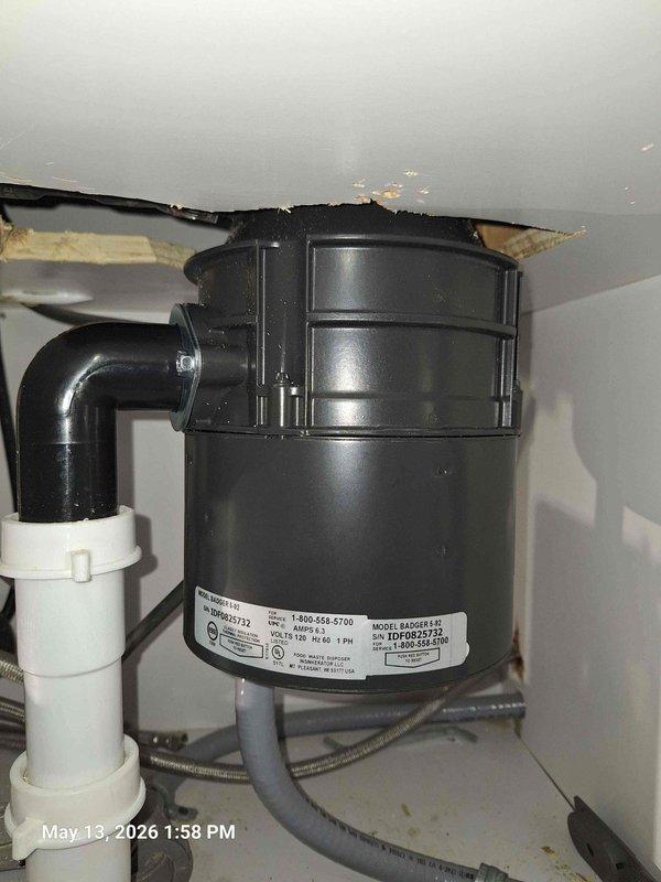 Installed new black garbage disposal unit under kitchen sink to replace customer's existing unit. Connected disposal to existing PVC drain line system and secured all plumbing connections. Wired electrical connections and tested unit for proper operation and drainage flow.