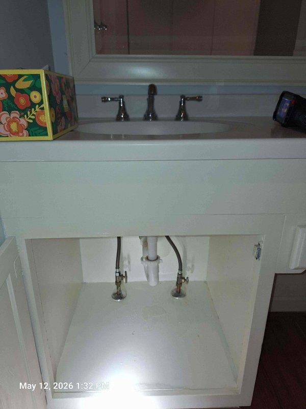 Completed real estate inspection per home inspection report requirements. Inspected and photographed kitchen sink installation, verifying proper mounting of stainless steel basin in countertop with functional faucet assembly. Examined bathroom vanity plumbing beneath sink, documenting supply line conditions and connections to faucet fixtures. Noted aging visible on supply line fittings. Sump pump inspection could not be completed or was not accessible during visit. All accessible plumbing fixtures photographed for documentation purposes. Completed real estate inspection per home inspection report requirements. Inspected and photographed kitchen sink installation, verifying proper mounting of stainless steel basin in countertop with functional faucet assembly. Examined bathroom vanity plumbing beneath sink, documenting supply line conditions and connections to faucet fixtures. Noted aging visible on supply line fittings. Sump pump inspection could not be completed or was not accessible during visit. All accessible plumbing fixtures photographed for documentation purposes.