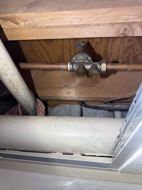 Continued inspection of residential plumbing system with focus on water pressure regulation and supply line components. Accessed attic space to examine and photograph pressure regulator valve assembly mounted on copper supply line, including associated shutoff valves and brass fittings. Verified pressure gauge readings and documented current system pressure status, noting gauge indicating near-zero pressure reading on 0-200 PSI scale. Inspected condition of copper piping, PVC drain lines, and electrical wiring routed through ceiling space. Assessment included visual examination of valve operation, connection integrity, and overall system configuration for compliance with plumbing standards. Continued inspection of residential plumbing system with focus on water pressure regulation and supply line components. Accessed attic space to examine and photograph pressure regulator valve assembly mounted on copper supply line, including associated shutoff valves and brass fittings. Verified pressure gauge readings and documented current system pressure status, noting gauge indicating near-zero pressure reading on 0-200 PSI scale. Inspected condition of copper piping, PVC drain lines, and electrical wiring routed through ceiling space. Assessment included visual examination of valve operation, connection integrity, and overall system configuration for compliance with plumbing standards.