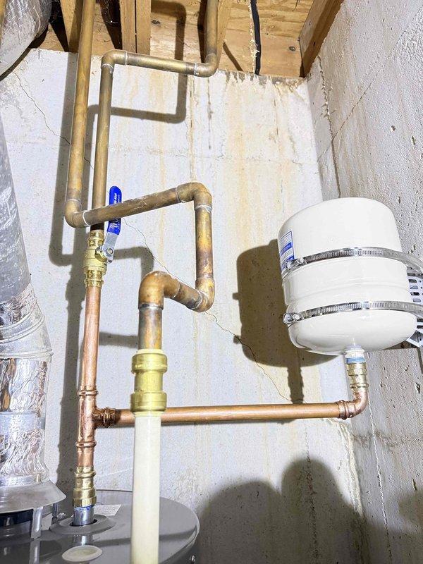 Responded to service call for leaking gas water heater. Upon inspection, identified active leak at gas supply connection point on Rheem residential water heater unit. Shut off gas supply using existing blue-handled ball valve, disconnected compromised gas line fittings, and replaced failed components with new brass connectors and proper pipe sealant rated for natural gas applications. Pressure tested all gas connections using approved leak detection solution to verify system integrity. Restored gas supply, cycled unit through startup sequence, and confirmed proper ignition and operation with no detectable leaks. Inspected associated plumbing connections including copper water lines, expansion tank mounting, and pressure relief valve for any additional issues requiring attention.