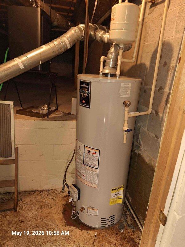 Responded to service call for reported water heater leak on 50-gallon gas unit. Upon arrival, inspected water heater installation in basement utility area and confirmed active leak condition. Visual inspection revealed significant water damage and rust staining on concrete floor beneath and around unit, indicating prolonged leak situation. Examined all connections, fittings, and tank integrity. Water heater showed signs of tank failure at base with corrosion present. Due to compromised tank integrity and extent of leakage, recommended immediate replacement to prevent further water damage and potential flooding. Unit replacement required to restore hot water service and eliminate ongoing leak hazard.