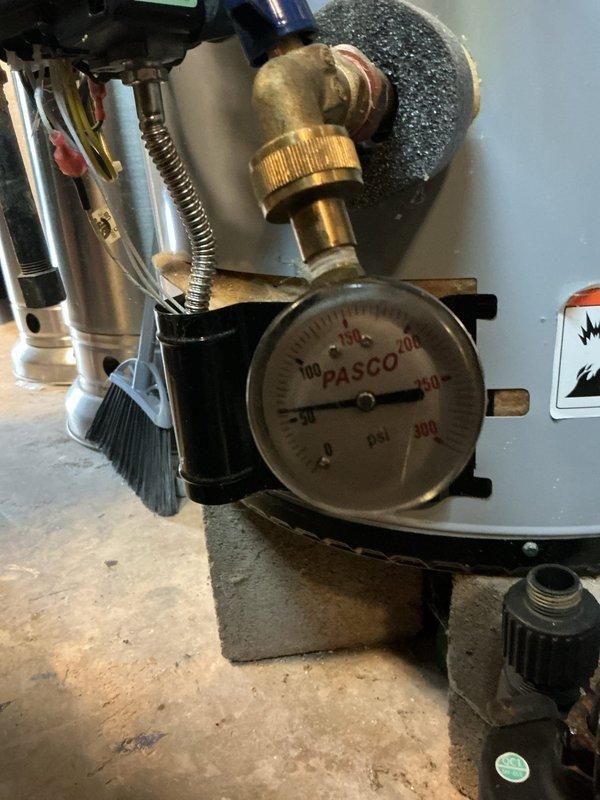 Responded to customer complaint of high-pitched noise in plumbing system. Upon inspection, diagnosed water hammer and excessive system pressure as the source of the screaming pipe sounds. Inspected pressure regulation equipment in basement mechanical room, including PASCO pressure gauge reading and PRV assembly with brass fittings, as well as attic-mounted well pump system with pressure tank and associated piping. Documented existing equipment conditions and pressure readings to determine appropriate corrective measures for eliminating noise and protecting plumbing fixtures from pressure-related damage.